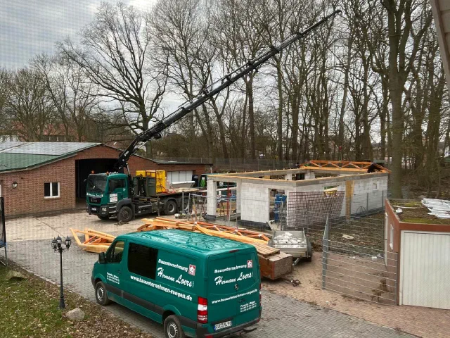 Kranwagen und Firmenfahrzeug auf einer Baustelle