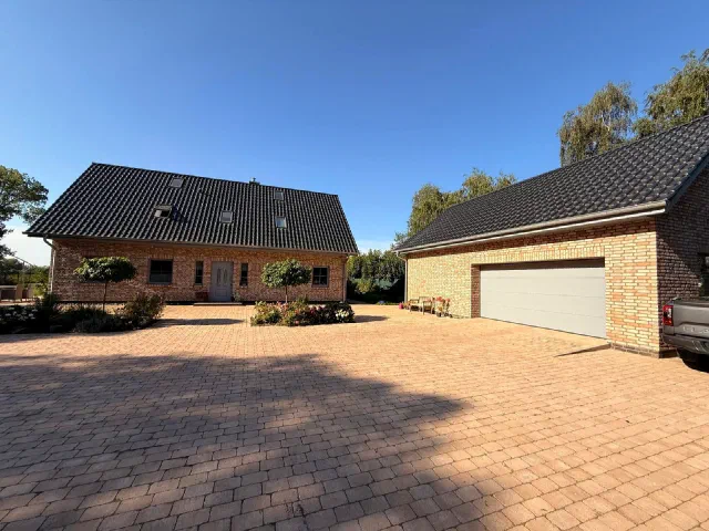 Klinkerhaus mit angebauter Doppelgarage und gepflasterter Hoffl&auml;che