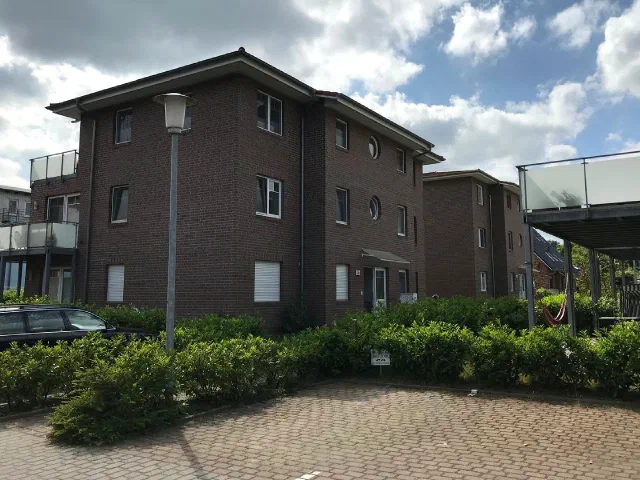 Mehrfamilienhaus aus dunklem Klinker mit Stellpl&auml;tzen