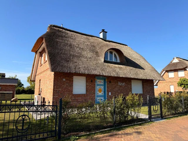 Klinkerhaus mit Reetdach, Gaube und farbig gestaltetem Hauseingang