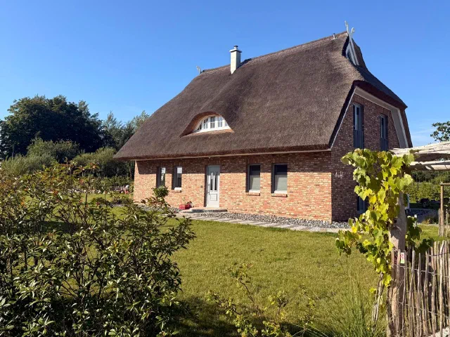 Freistehendes Wohnhaus aus rotem Klinker mit Reetdach