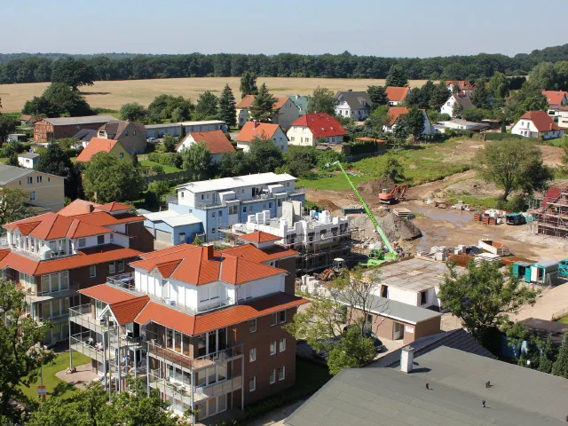 Luftaufnahme eines Wohnquartiers, im Hintergrund Neubauten mit Kran