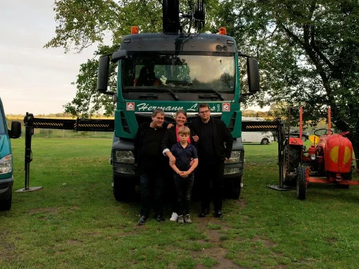 Die Familie Loers vor dem Kranwagen der Bauunternehmung, daneben Servicefahrzeug und Baumaschinen